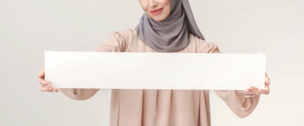 istock Islamic woman with blank board on white 1061242848