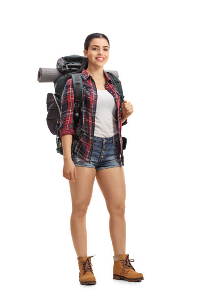 Female hiker with backpack standing and looking at the camera