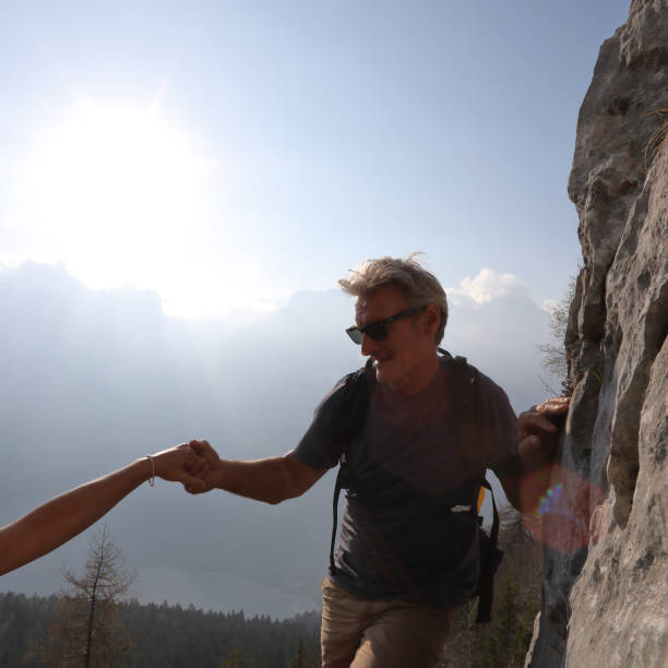 hiker оказывает помощь товарищу по команде, горы - 24186 стоковые фото и изображения