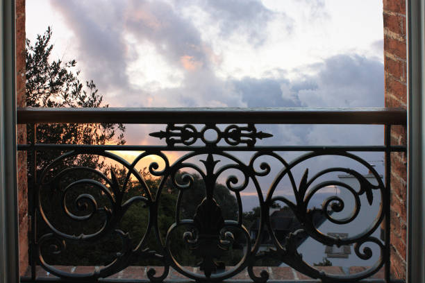istock Retro style window Exterior view Wrought iron balcony  Sunset 1061253608