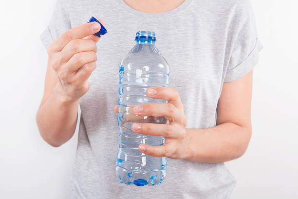 istock Young woman drinking water form a bottle at home. 1061254880