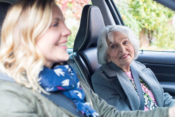 la vicina di casa dà alla donna anziana un passaggio in auto - driving senior adult car women foto e immagini stock