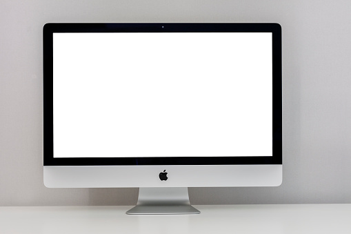 Canakkale, Turkey - June 27, 2018:  Apple iMac 27 inch desktop computer displaying 5k solution White screen with ultra slim design on a Gray background. iMac produced by Apple Inc.