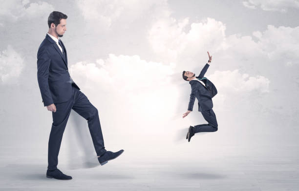 istock Big boss kicking little employee 1061258472