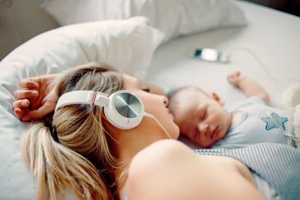 escuchar música y dormir la siesta con su bebé de la madre - mothers audio fotografías e imágenes de stock