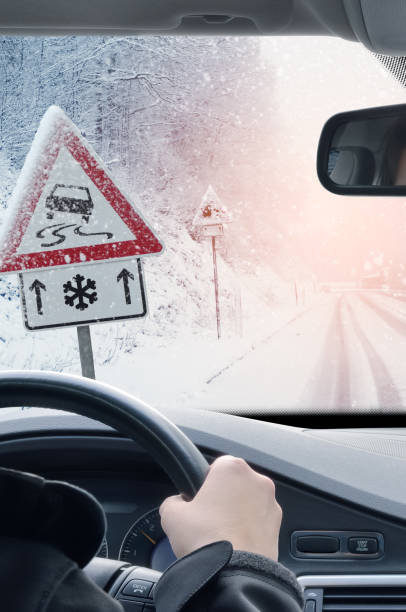 winter driving - fahrt auf einer verschneiten straße - drivers point of view country road snowing blizzard stock-fotos und bilder
