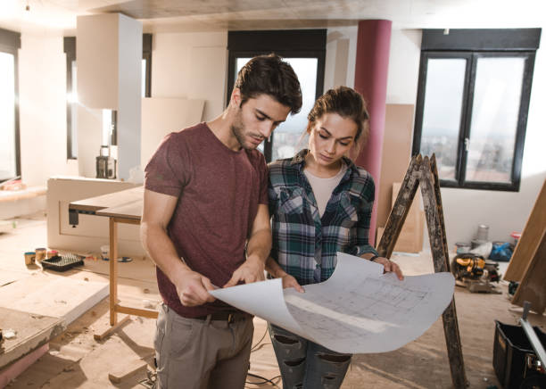istock Young couple looking at their housing project on construction site. 1061273474