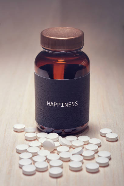 istock A drug container with black label written happiness on it 1061278180