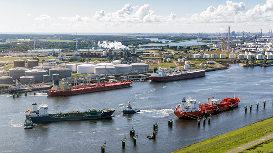 Aerial view of various oil tankers at a busy oil storage terminal port.