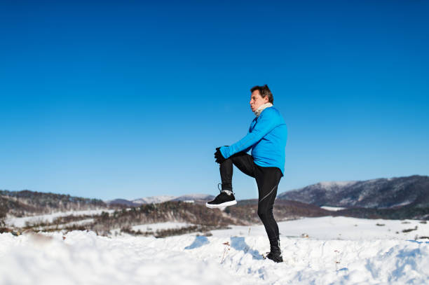 istock Senior man stretching before the run in winter nature. Copy space. 1061282874