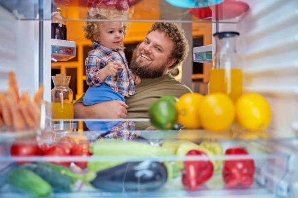 istock Father and son standing in front of opened fridge. 1061282954