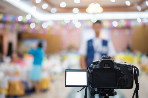 istock Reporter on Video camera, camcorder interviews, operator working for record speaker or Presenter in convention hall, blak screen. Interview is conversation where questions are asked and answers given. 1061283258