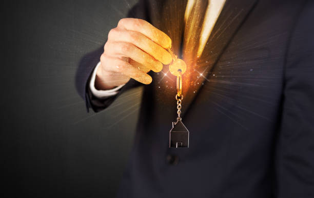 istock Man in suit hand over keys 1061284468