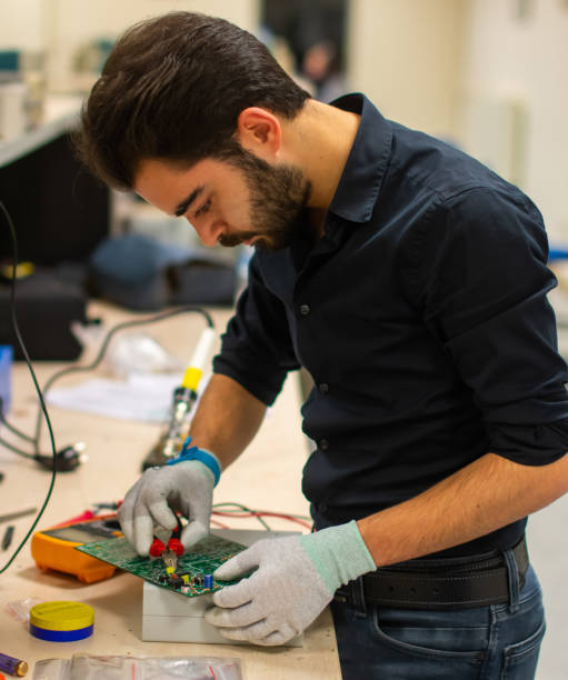 técnico de trabajo en un tablero del pwb - service electronics industry circuit board capacitor fotografías e imágenes de stock