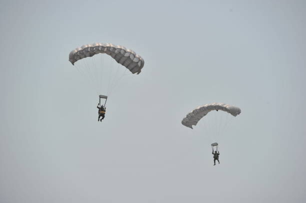 istock Low Angle View Of People Paragliding Against Clear Sky 1061289428