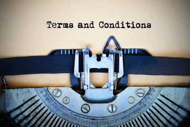 Photo of Drafting terms and conditions of an agreement using a retro typewriter