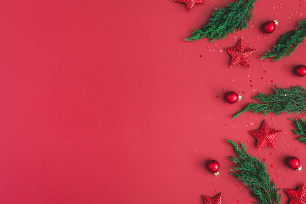 Christmas composition. Christmas red decorations, fir tree branches on red background. Flat lay, top view, copy space