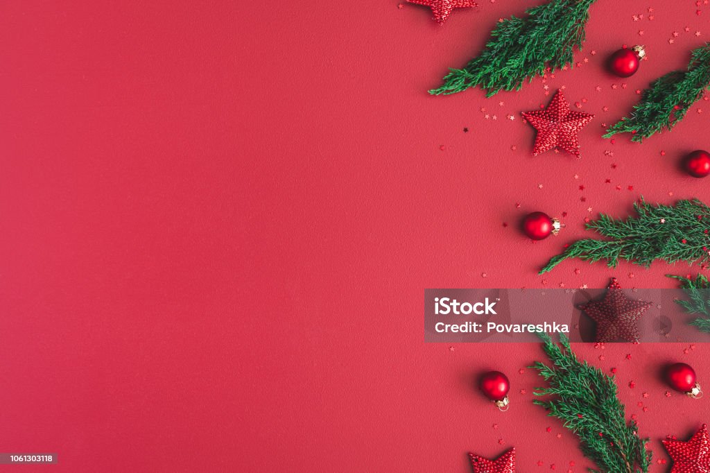 Christmas composition. Christmas red decorations, fir tree branches on red background. Flat lay, top view, copy space Christmas Stock Photo