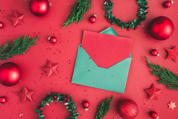 istock Christmas composition. Christmas decorations, fir tree branches, envelope on red background. Flat lay, top view, copy space 1061303246