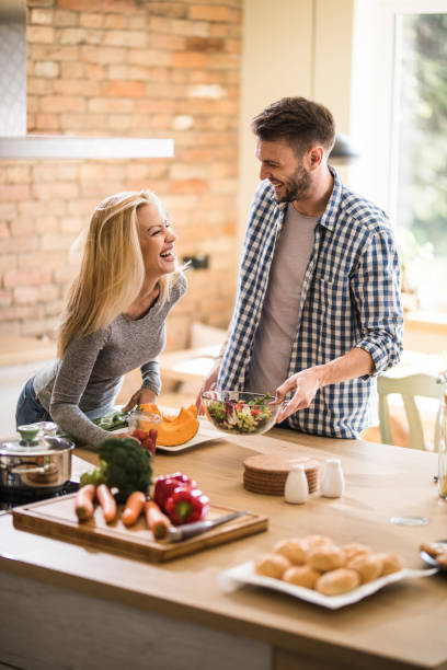 istock Cheerful couple laughing while preparing healthy meal in the kitchen. 1061304560
