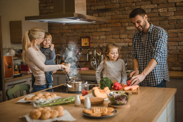 istock Young smiling parents enjoying while preparing lunch with their kids in the kitchen. 1061306076