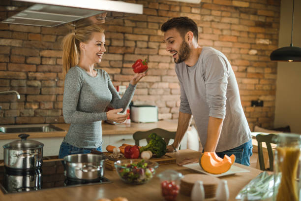 istock Young happy couple having fun while preparing healthy lunch in the kitchen. 1061306398