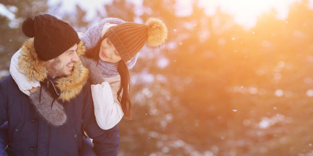 figlarna uśmiechnięta para spacerująca po zimowym lesie. obszar kopiowania - family winter walking fun zdjęcia i obrazy z banku zdjęć