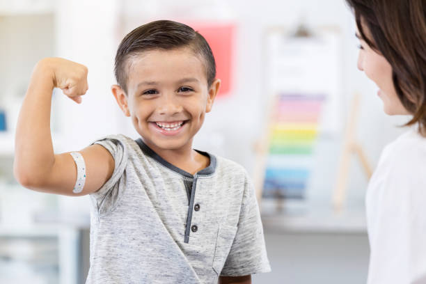 brave petit garçon exhibe de bandage de bras au pédiatre - child human muscle flexing muscles little boys photos et images de collection