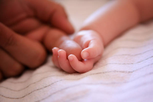 istock baby holding father's finger 1061309026