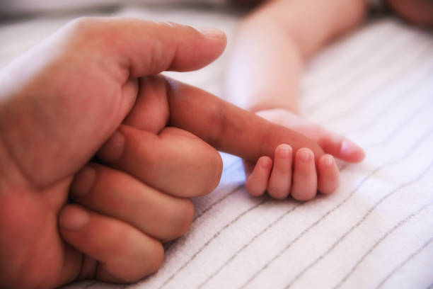 istock baby holding father's finger 1061313558