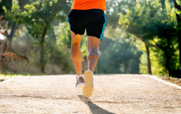 istock Back view of young dynamic athlete runner man with fit strong body training on beautiful summer sunset in green park running and workout in fitness well being and healthy lifestyle concept. 1061314978