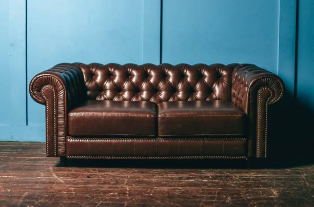 pelle lussuosa, divano marrone, parete blu. mobili vintage classici. - armchair sofa leather brown foto e immagini stock