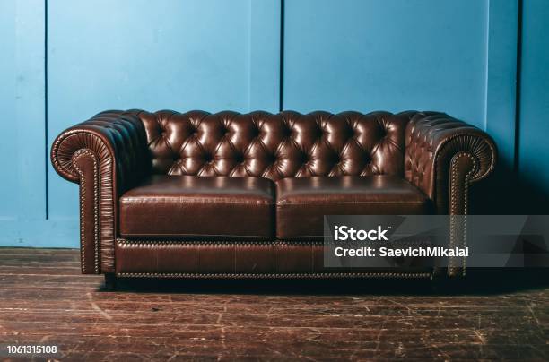 Luxurious Leather Brown Sofa Blue Wall Classic Vintage Furniture Stock Photo - Download Image Now