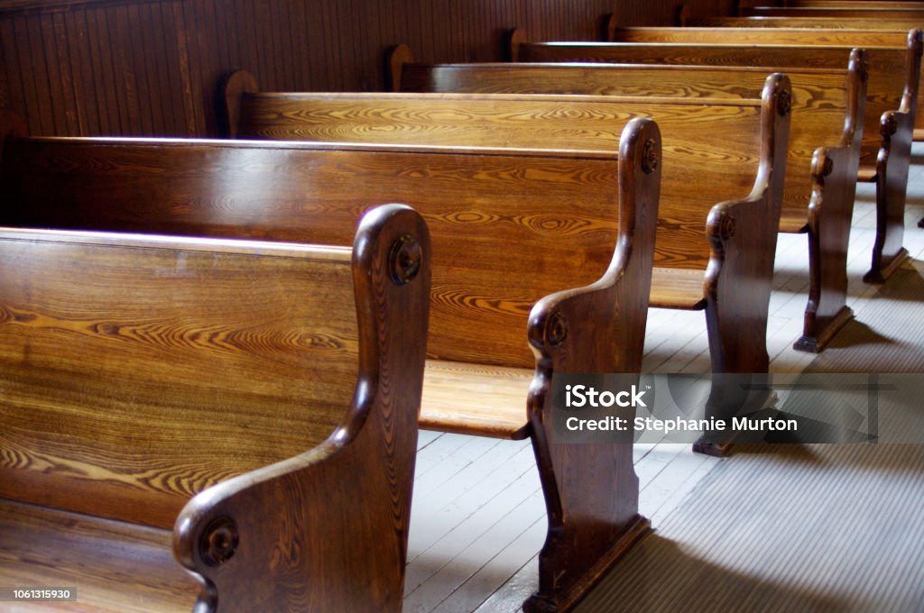 Interior of old church with carved wooden pews Carved Wooden pews in church in sunshine Church Stock Photo