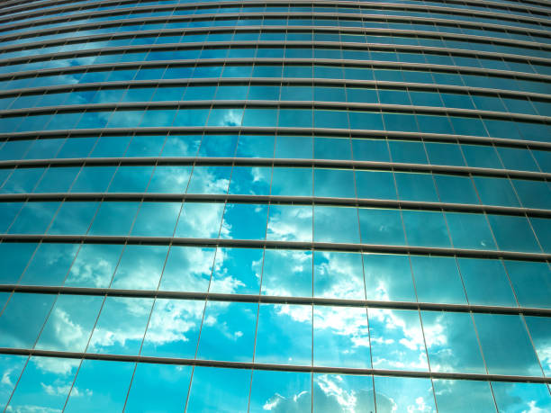 istock Looking Up a Tall Glass Building With Clouds and Sky reflected 1061318752