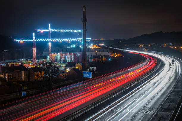 A Long exposure photo of cars passing large illuminated cranes in Sheffield, South Yorkshire