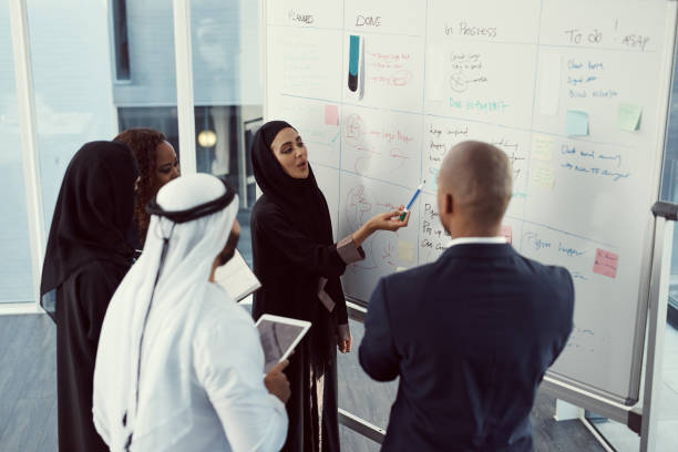 We've got a lot going on High angle shot of a group of diverse business colleagues working together on a whiteboard in their office saudi arabia stock pictures, royalty-free photos & images