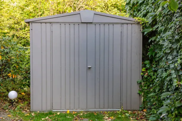 Gardening tools storage shed in the house backyard, autumn nature background