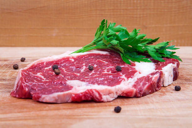 istock Fresh raw beef steak on wooden and white background. 1061324534