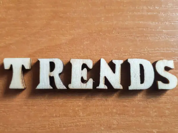 Photo of The word 'trends' made of wooden letters. wood inscription on table