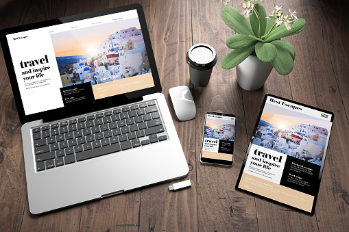 3d rendering of three devices with responsive travel online website on screen on wooden desktop top view