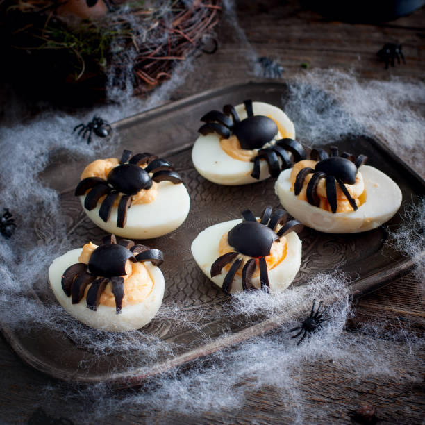 istock Stuffed eggs for Halloween adorned with spiders from olives, selective focus 1061328904