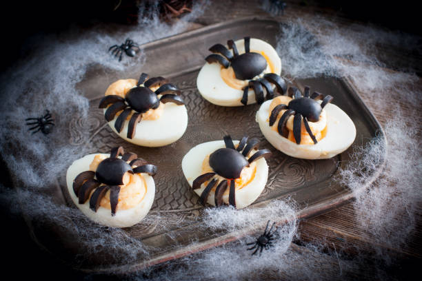 istock Stuffed eggs for Halloween adorned with spiders from olives, selective focus 1061328906