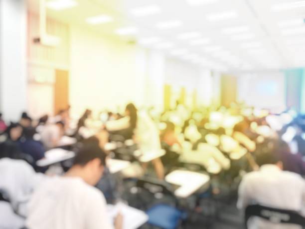 istock Blurred image of large examination room with students sitting on lecture chair doing final exam, studying, learning, doing final test in exam hall in university or campus. Education concept. 1061329840