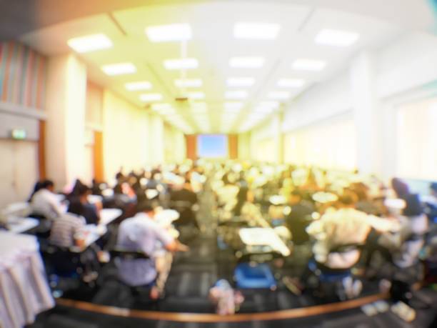 istock Blurred image of large examination room with students sitting on lecture chair doing final exam, studying, learning, doing final test in exam hall in university or campus. Education concept. 1061329850