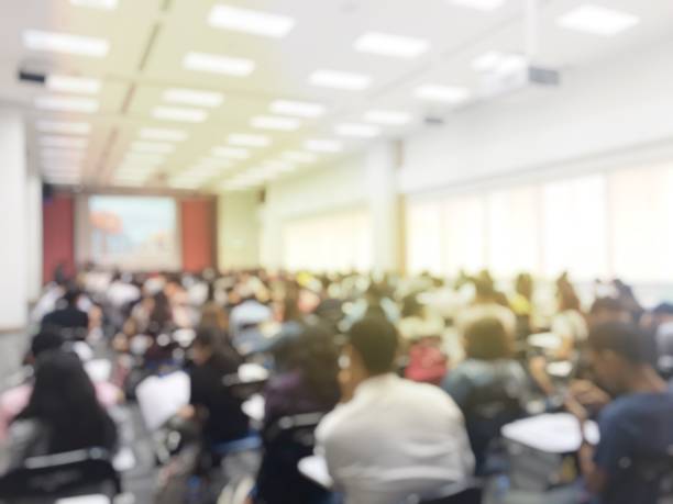 istock Blurred image of large examination room with students sitting on lecture chair doing final exam, studying, learning, doing final test in exam hall in university or campus. Education concept. 1061329880