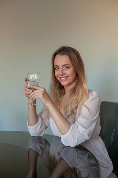 istock Blond girl sat at a table with glass 1061332780