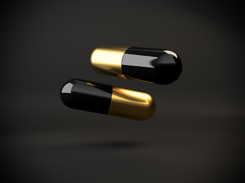 Minimalism and contrast concepts with two golden and black colored pills. ( 3d render )