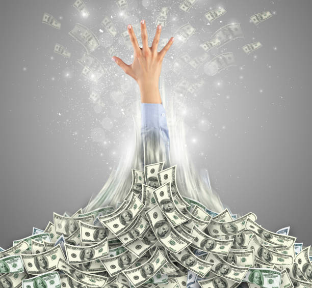 istock Hand bursting out from a money heap 1061337478