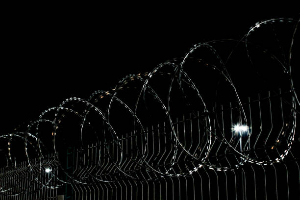 istock barb wire fence at night 1061338250